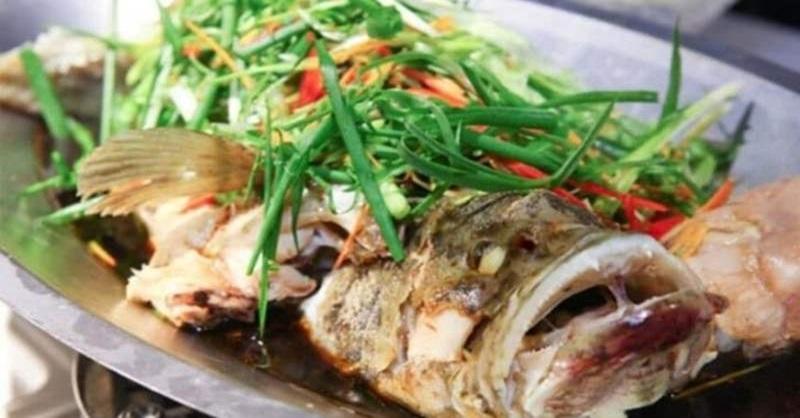 Đĩa cá mú hấp xì dầu nóng hổi, hấp dẫn, sẵn sàng để thưởng thức cùng cơm trắng.