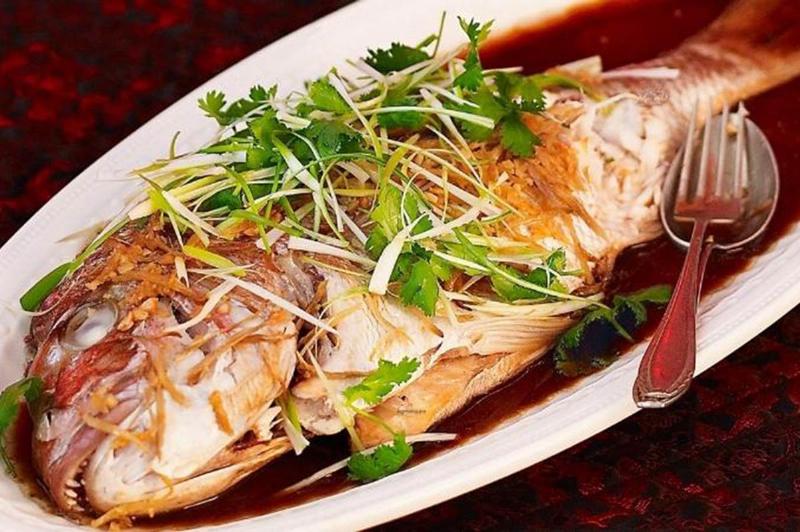 Cá mú đã làm sạch sẵn sàng để tẩm ướp với gừng, hành, nấm cho món hấp xì dầu.