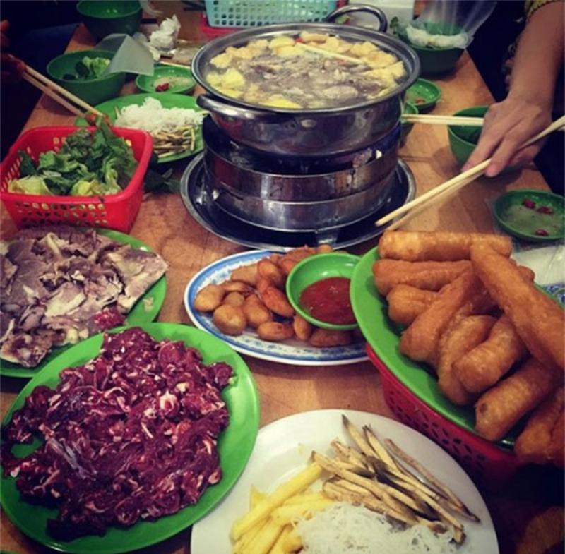 Nồi lẩu nghi ngút khói với nhiều loại rau xanh mướt đang được nhúng