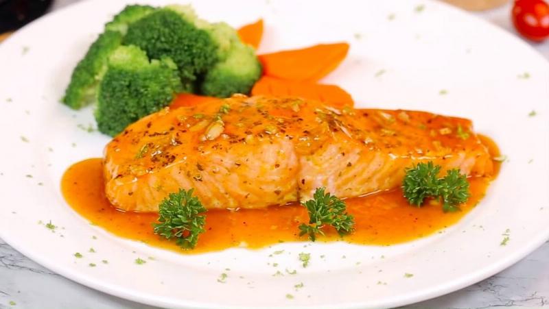 Phết dầu oliu lên miếng cá hồi trước khi nướng bằng nồi chiên không dầu