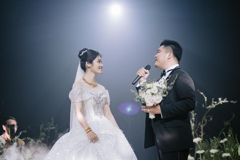 Hình ảnh nhóm bạn bè đang vui vẻ trò chuyện và chia sẻ niềm vui với cô dâu chú rể tại buổi tiệc cưới, không khí ấm áp và thân thiết.