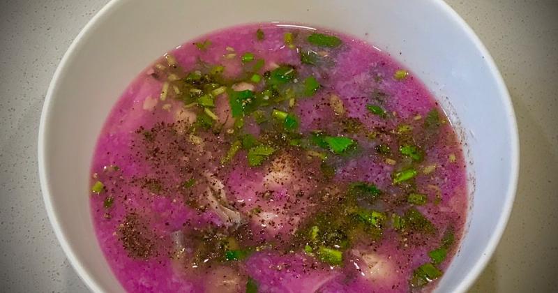 Bát canh đầu cá hồi măng chua nóng hổi, garnished với thì là và hành lá