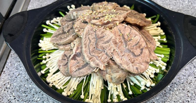 Bát canh chả cá Hàn Quốc nóng hổi với miếng chả cá, củ cải, và hành lá, bốc hơi nghi ngút