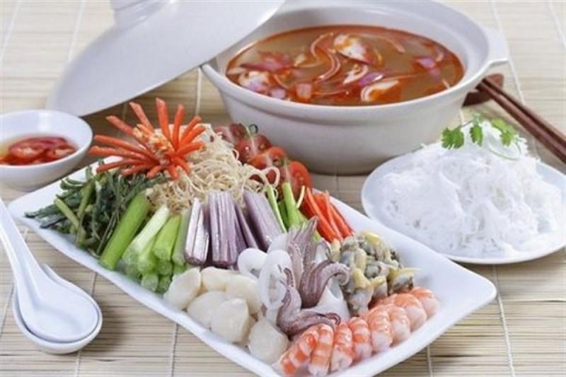 Nồi lẩu hải sản chua cay nghi ngút khói với đủ loại tôm, mực, nghêu hấp dẫn, màu sắc tươi tắn