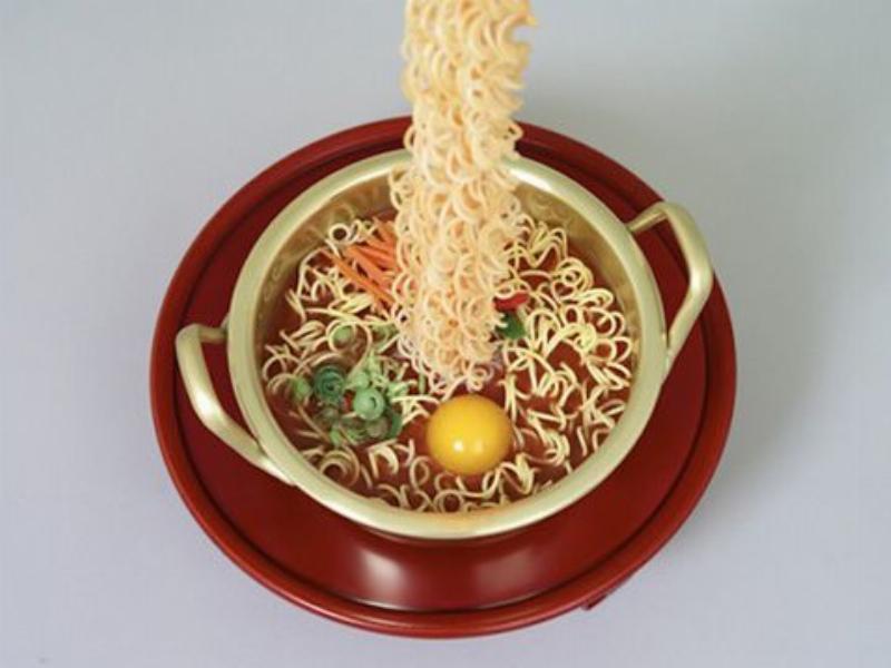 Một người trẻ đang húp mì cay Samyang và có biểu cảm cay nồng rõ rệt