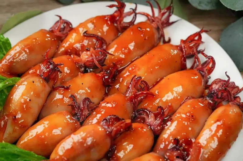 Món mực xào thập cẩm đãi tiệc được trình bày đẹp mắt trên đĩa sứ trắng, có trang trí